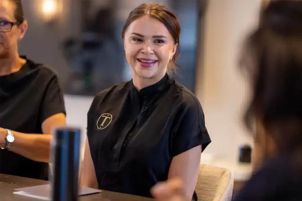 A receptionist welcoming a patient at the Treetops reception desk