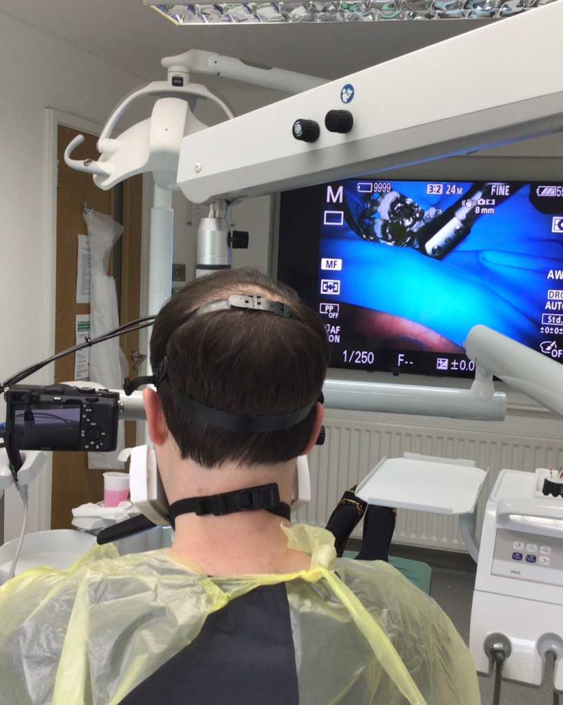 An endodontist working at the dental microscope
